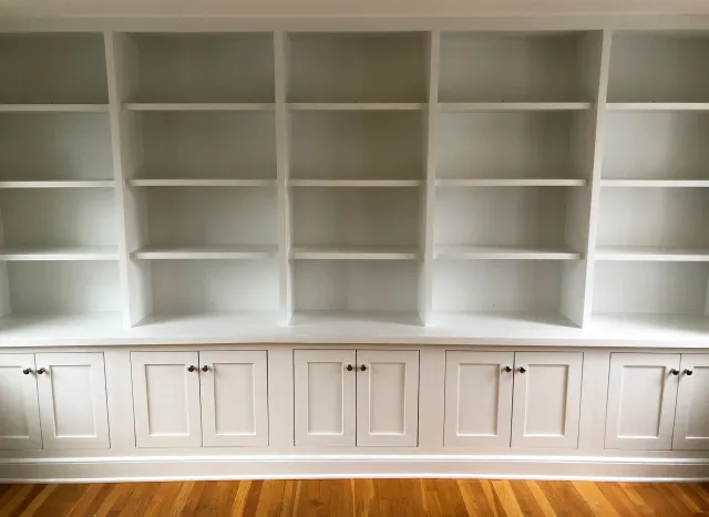 A 14-foot-wide, floor to ceiling unit with shelving and cabinets with inset doors