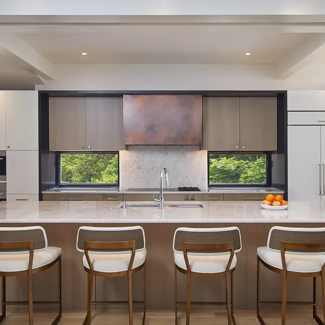 Back in Brookmont, because this one is worth a second look. The center of the house is open from top to bottom, letting natural light permeate the whole structure. Custom white oak slat screens wrap the stair, an aged copper hood anchors the range wall and ribbon windows put the tree canopy where a backsplash would normally be.

Neighborhoods like this are why we love building in Bethesda.

Architecture: @mcinturffarchitects 
Photos: @anice_hoachlander 

#CustomHomeBuilder #BethesdaMD #Brookmont #HomeRenovation #ModernHome #KitchenDesign #CopperRangeHood #DCDesign #MarylandHomes