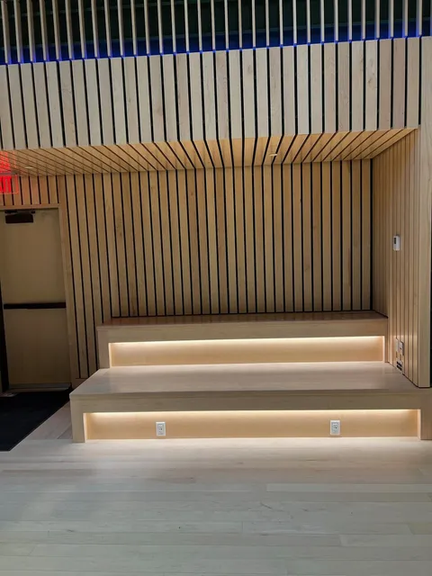 Slatted wood accent wall with integrated LED lighting and a floating step