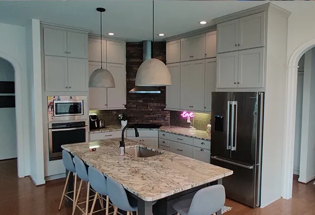 Remodeled kitchen with island seating, granite countertop, and stainless steel appliances