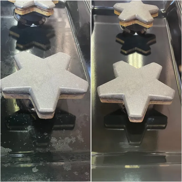 Silver star-shaped cookies with a shiny, metallic appearance, placed on a reflective black surface.