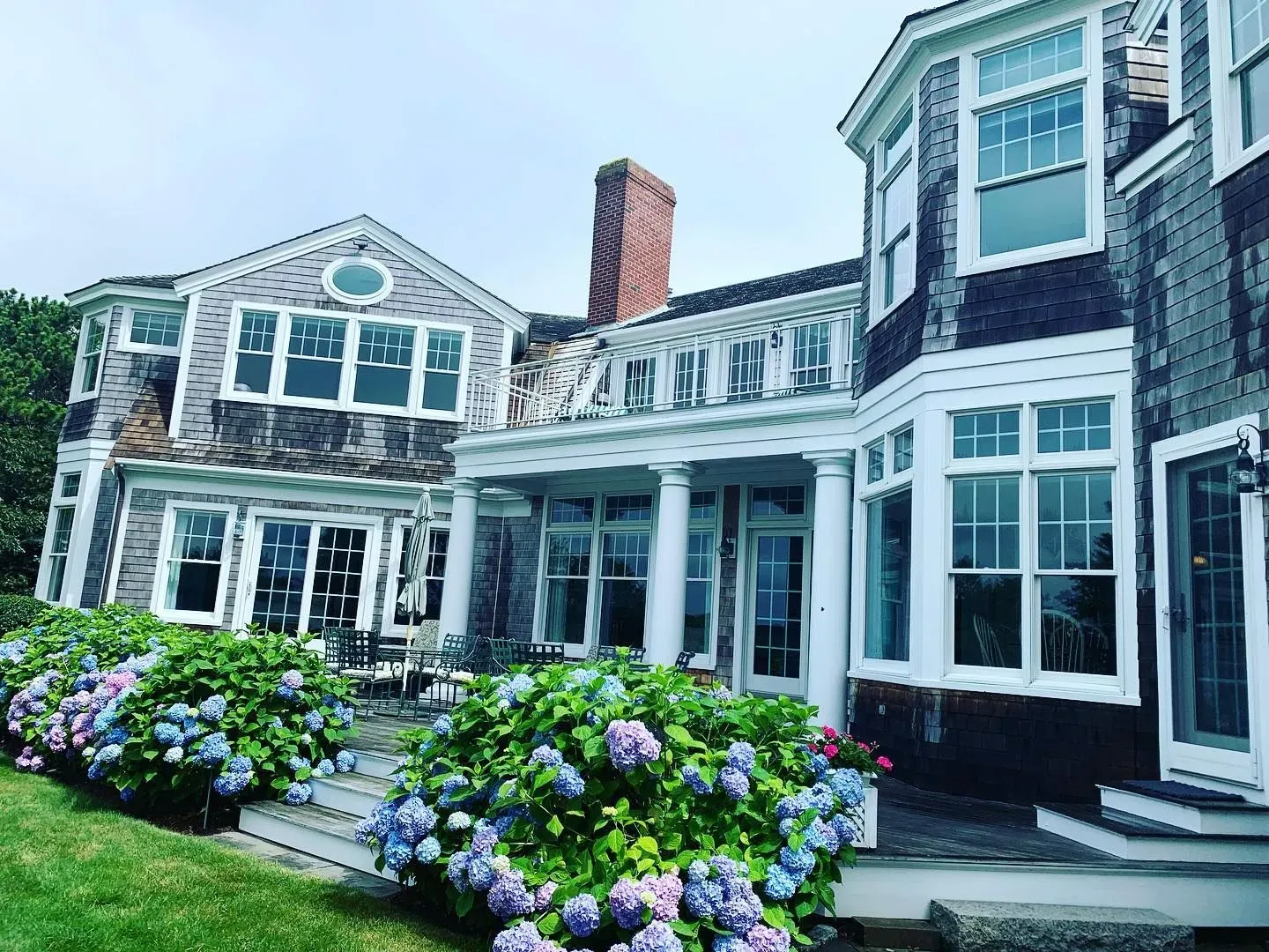 A large house with a lot of windows and flowers in front of it.