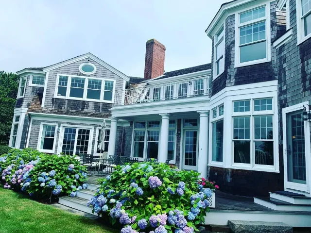 A large house with a lot of windows and flowers in front of it.
