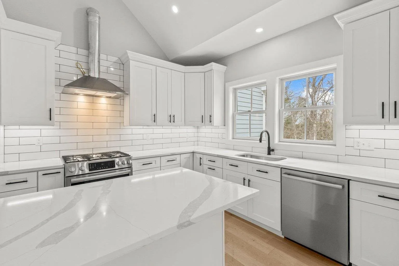 Custom white kitchen cabinetry with quartz island
