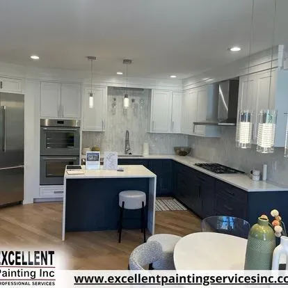 A kitchen with blue cabinets, white cabinets, stainless steel appliances and a large island.