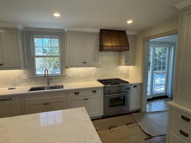 Custom kitchen cabinets with copper range hood and marble island