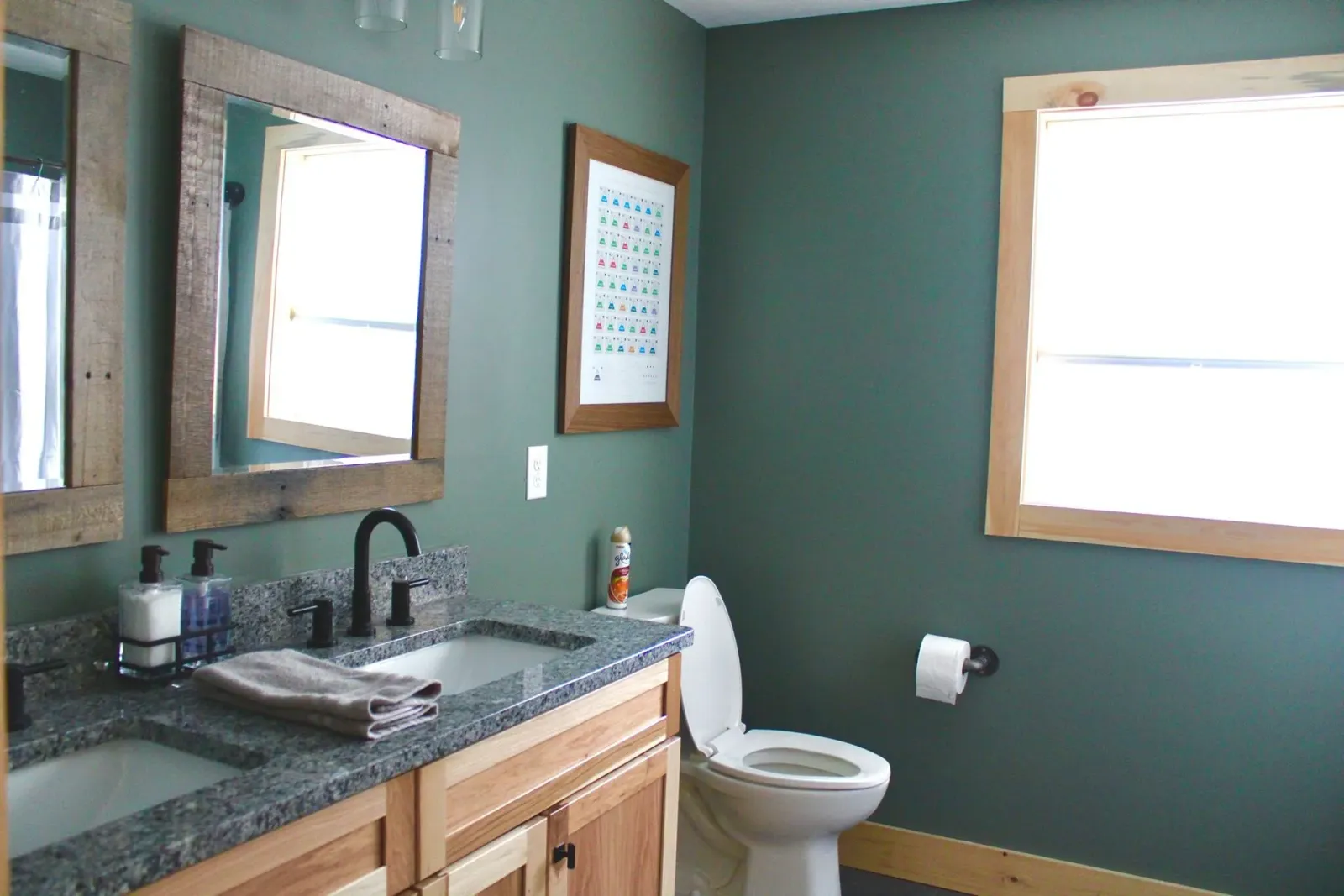A bathroom with a toilet a sink and two mirrors