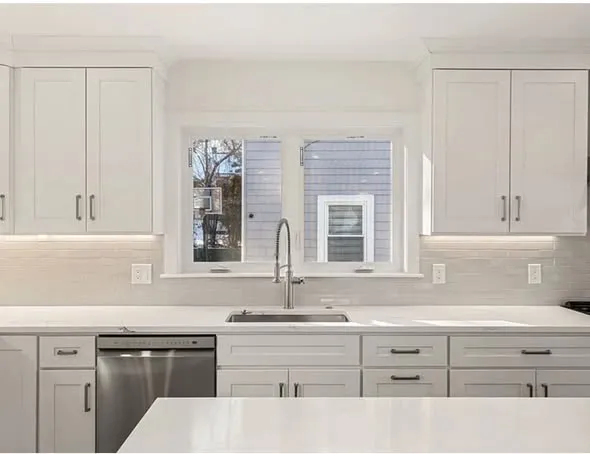 Finished kitchen with quartz counters and tile backsplash