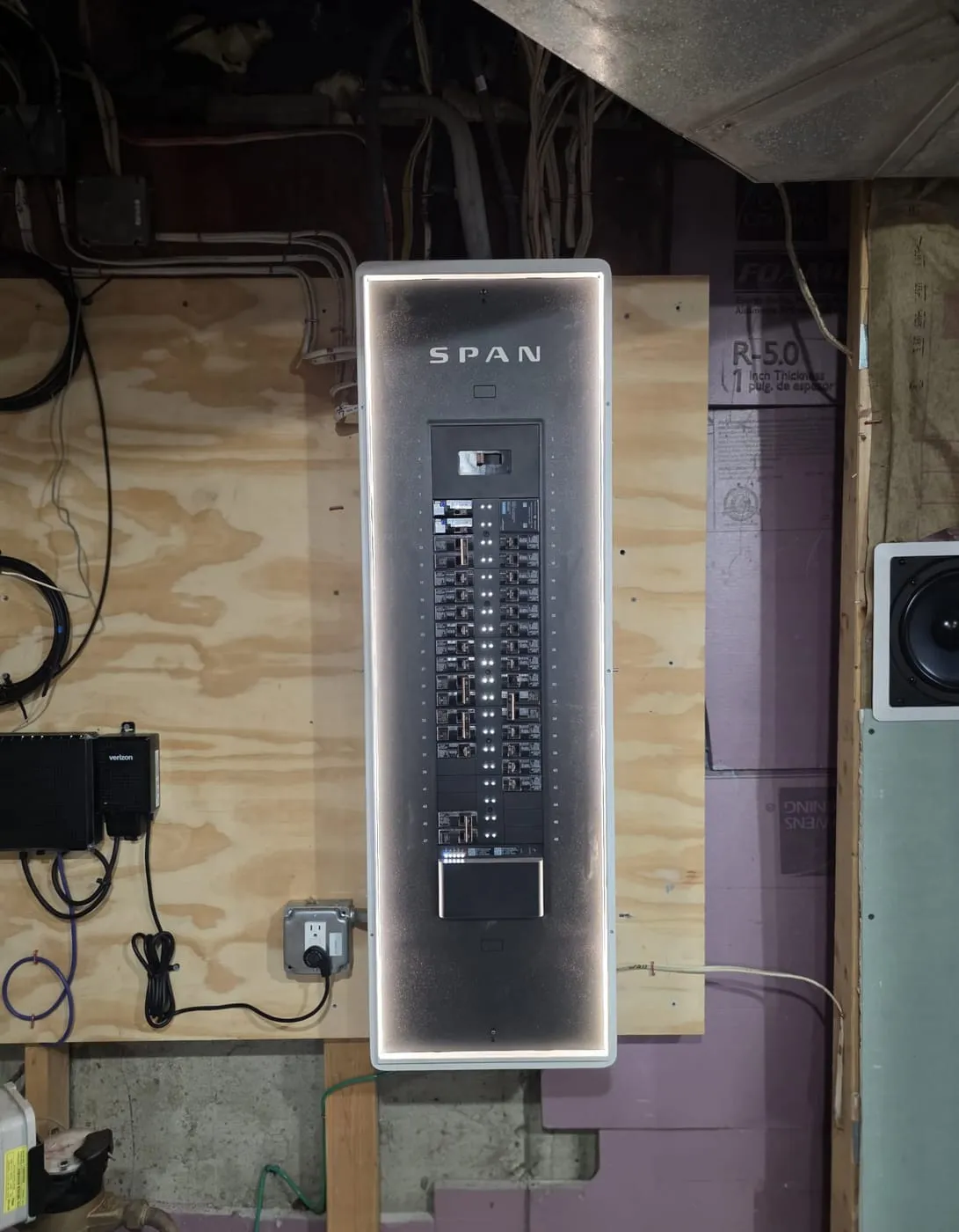 SPAN smart panel installed by Powered Up LLC, backlit and open to show the breaker layout