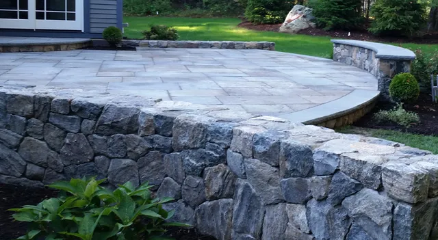 Curved stone retaining wall around a finished patio