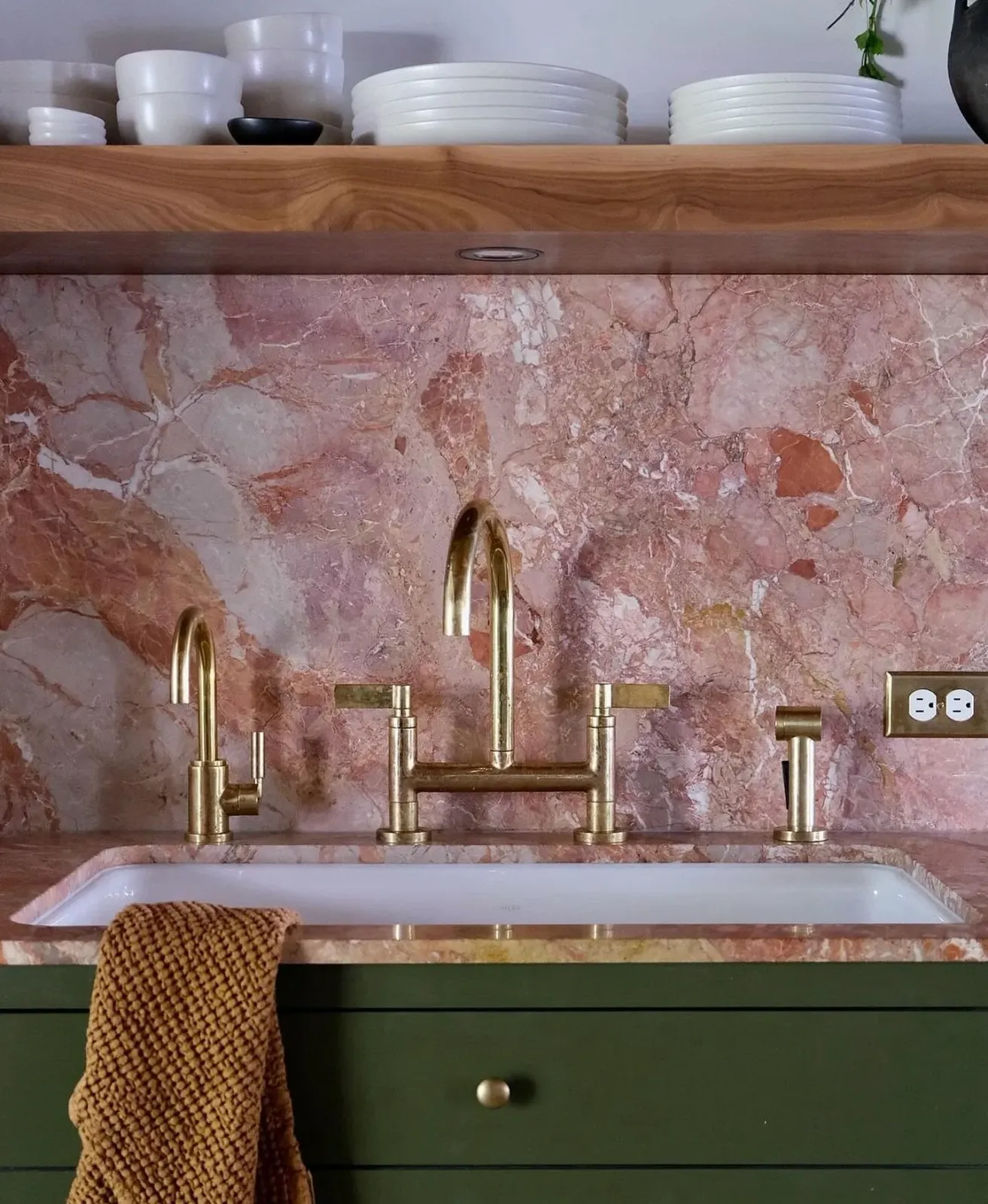 #Repost by @artistic_tile A mid-century inspired kitchen that blends elegance with natural details, &lsquo;Sans Souci&rsquo; features a sloping Breccia Pernice slab backsplash in peachy-rose tones, set against forest green cabinetry and brass accents