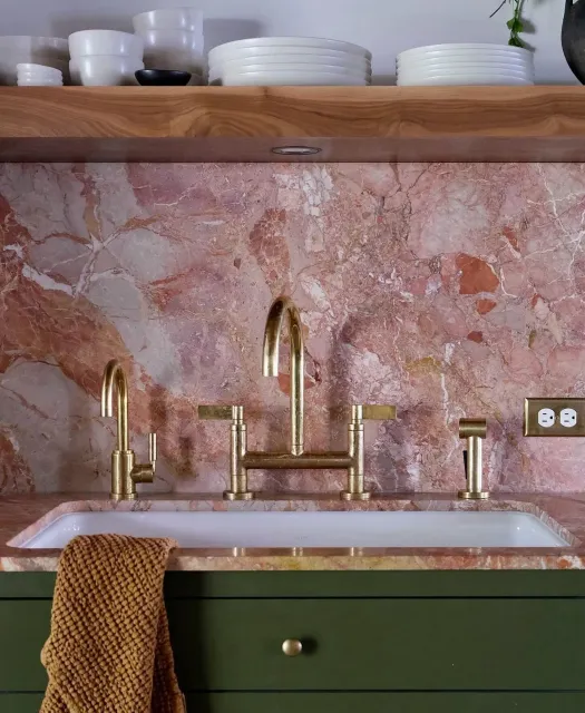 #Repost by @artistic_tile A mid-century inspired kitchen that blends elegance with natural details, &lsquo;Sans Souci&rsquo; features a sloping Breccia Pernice slab backsplash in peachy-rose tones, set against forest green cabinetry and brass accents