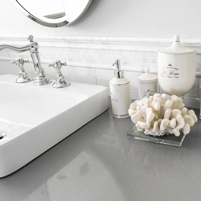 Bathroom sink with gray countertop, white tile backsplash, and chrome fixtures.