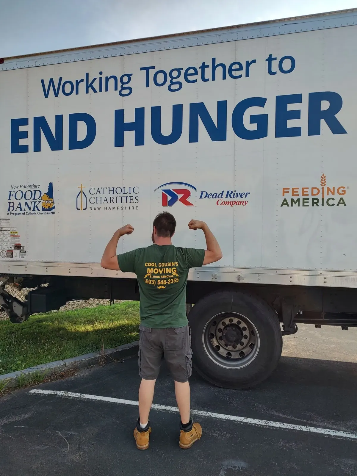 Person flexes in front of a white truck reading “Working Together to END HUNGER.”