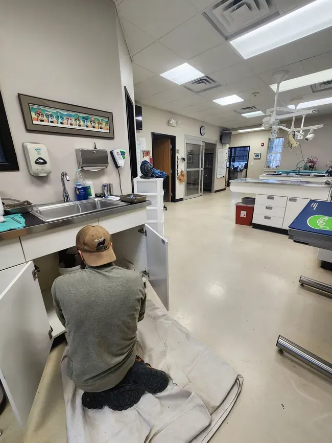 Person sitting on a hospital floor beside a counter, in a bright rehabilitation clinic.