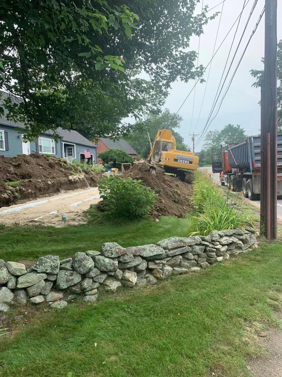 A bulldozer is moving dirt in front of a house.