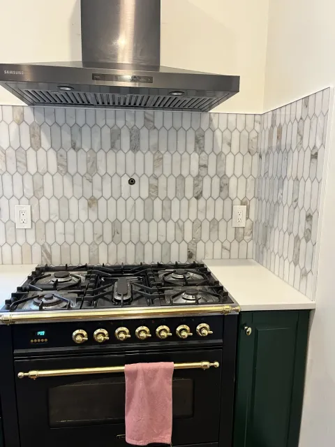 Marble picket tile backsplash behind a range