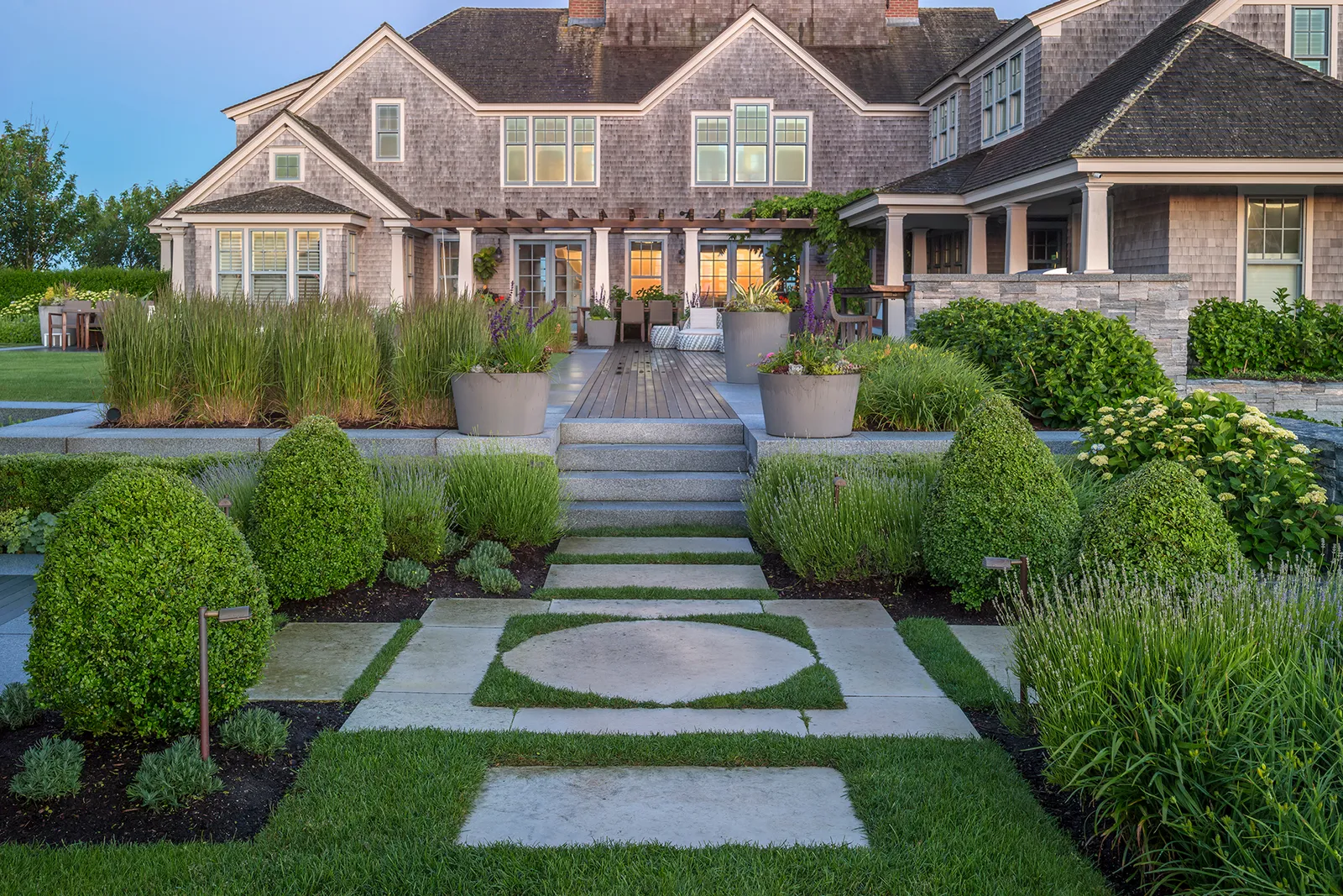 Formal entry garden with clipped boxwood and bluestone-and-turf paving