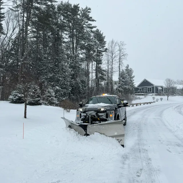 Picture of a truck plowing a driveway for snow removal service near me