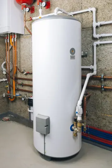 White water heater mounted on a wall, connected to power and water pipes.