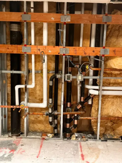 A wall with a lot of pipes in it