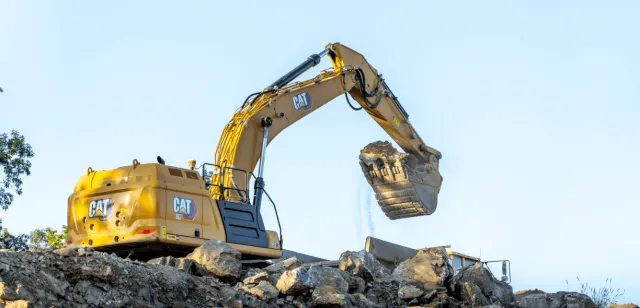 Sweeney, excavator, bucket holding dirt, earthwork-services-mi