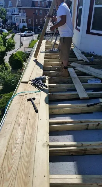 A man is standing on top of a wooden deck.