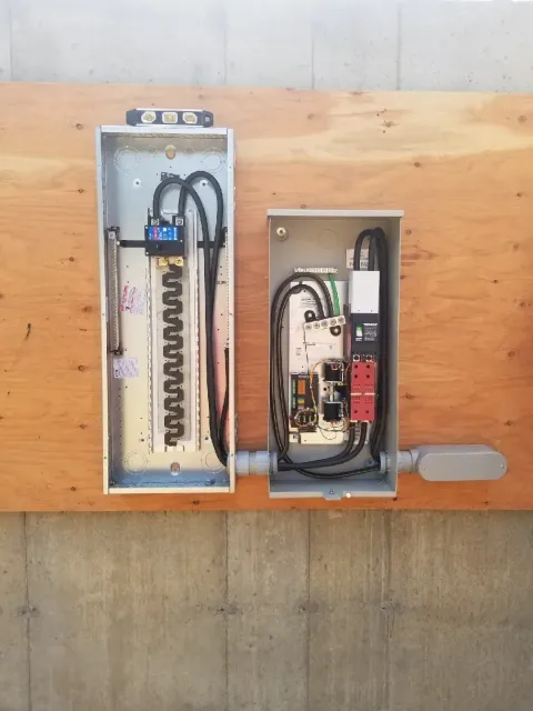 Two electrical boxes are sitting on top of a wooden table.