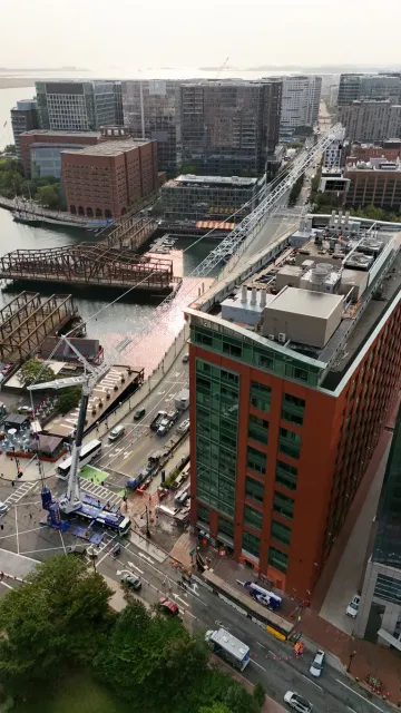 CJ Shaughnessy crane working the 470 Atlantic Avenue site, boom extended over the building beside Fort Point Channel