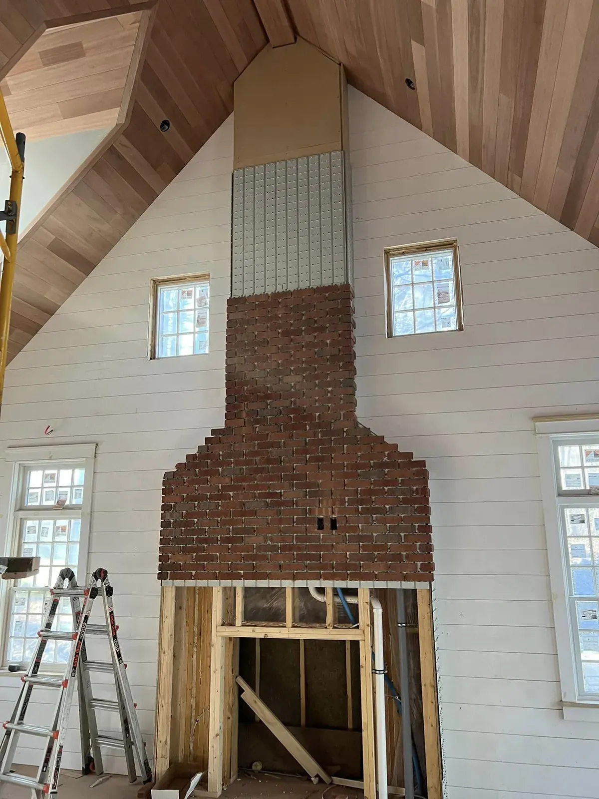 Custom brick fireplace centered in a vaulted interior