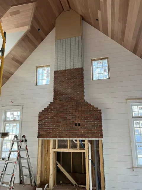 Custom brick fireplace centered in a vaulted interior