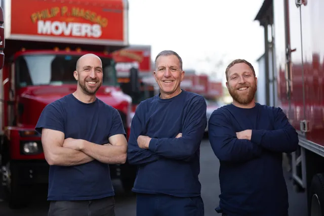 Our movers standing in front of a moving truck.