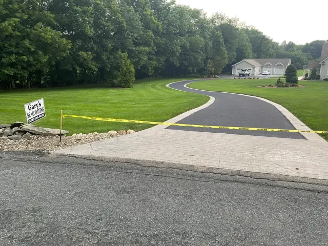 Freshly sealed winding driveway blocked by caution tape