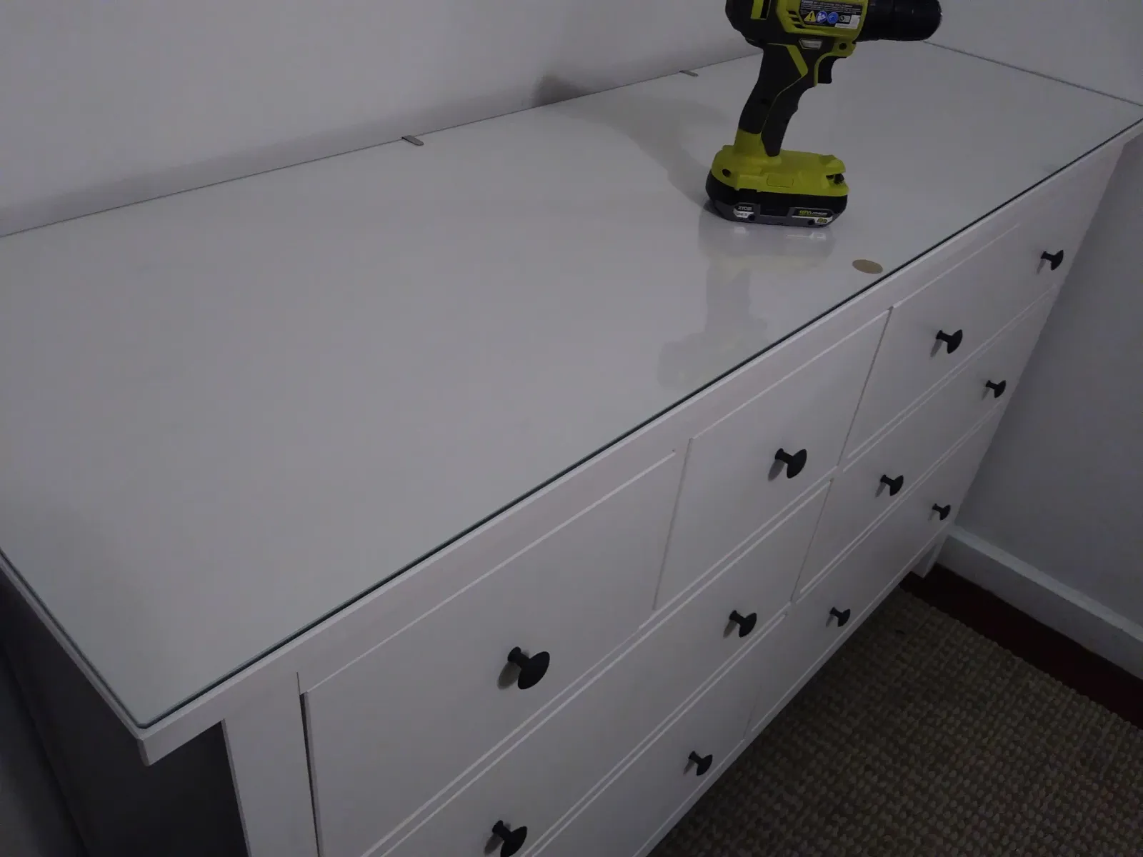 Assembled white six-drawer dresser, driver still on top