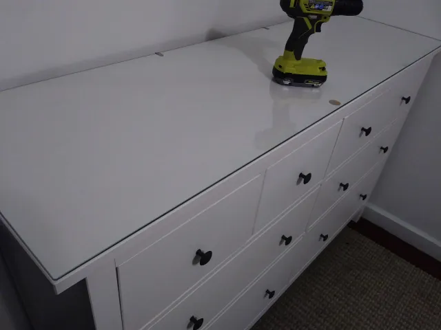 Assembled white six-drawer dresser, driver still on top