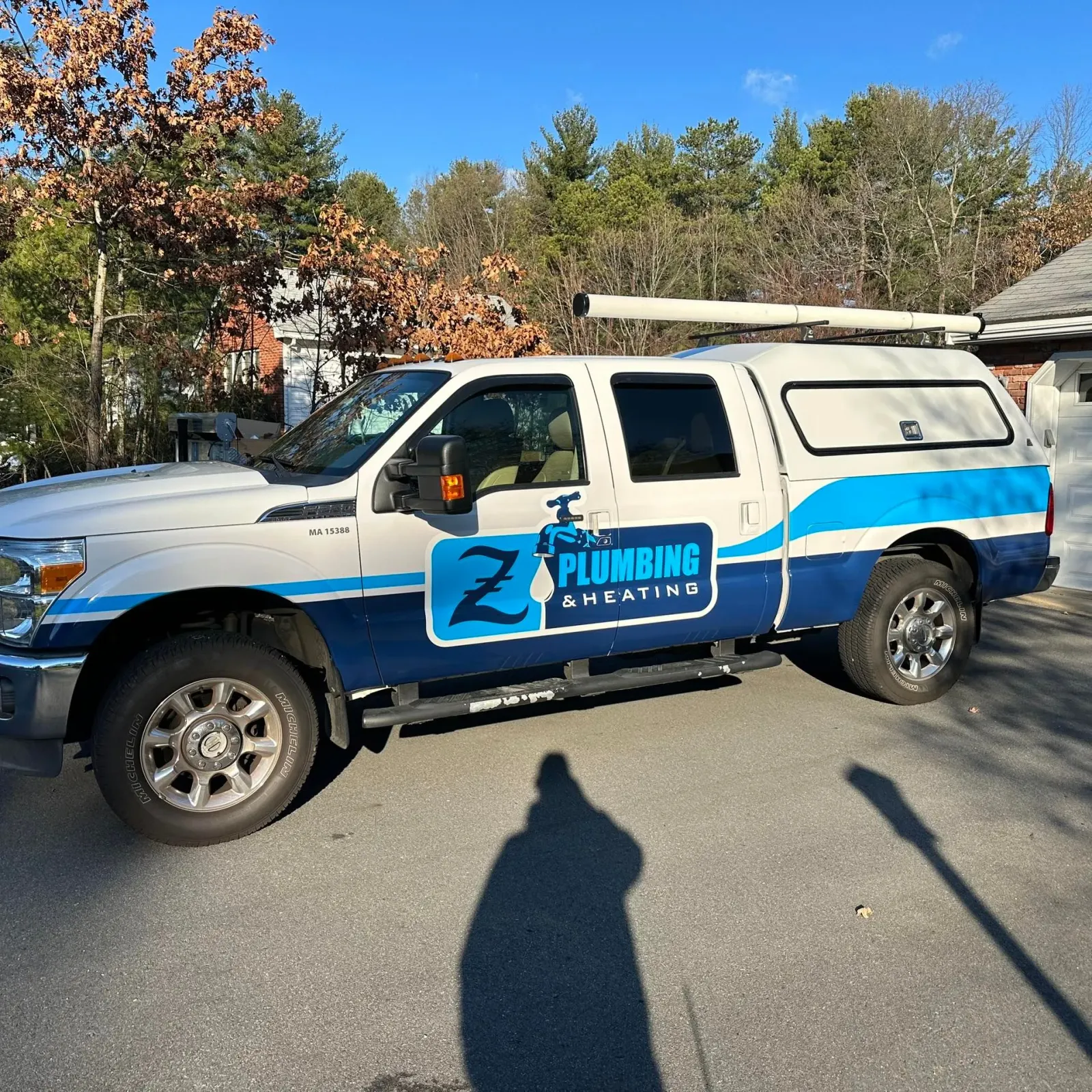 A plumbing truck is parked in front of a house