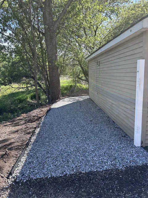 Crushed stone gravel walkway installed along the side of a house