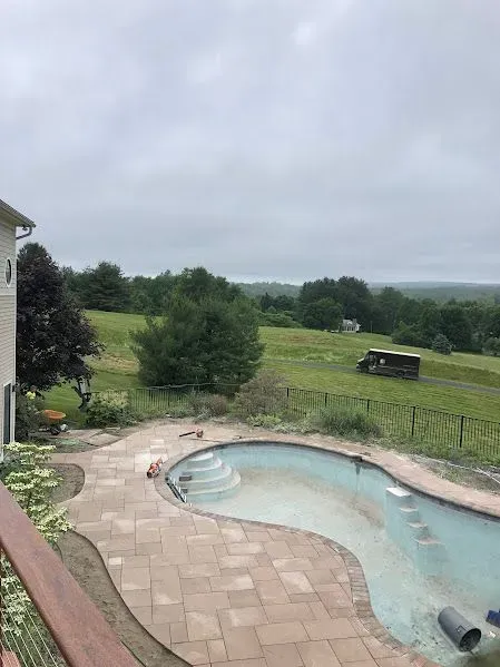 A large swimming pool is being built in the backyard of a house.