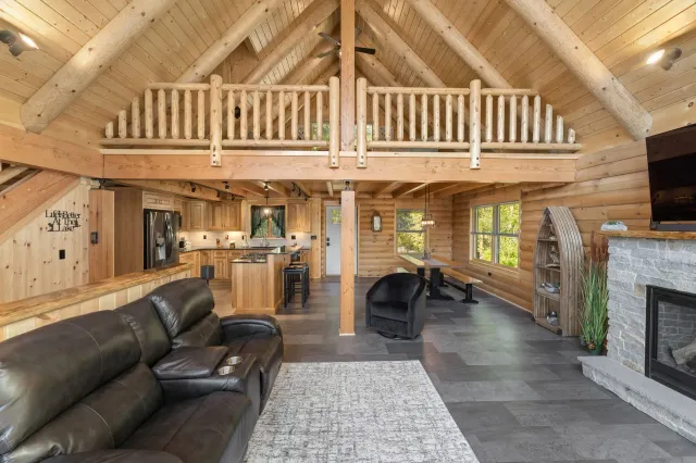 A living room in a log cabin with a couch and a fireplace.