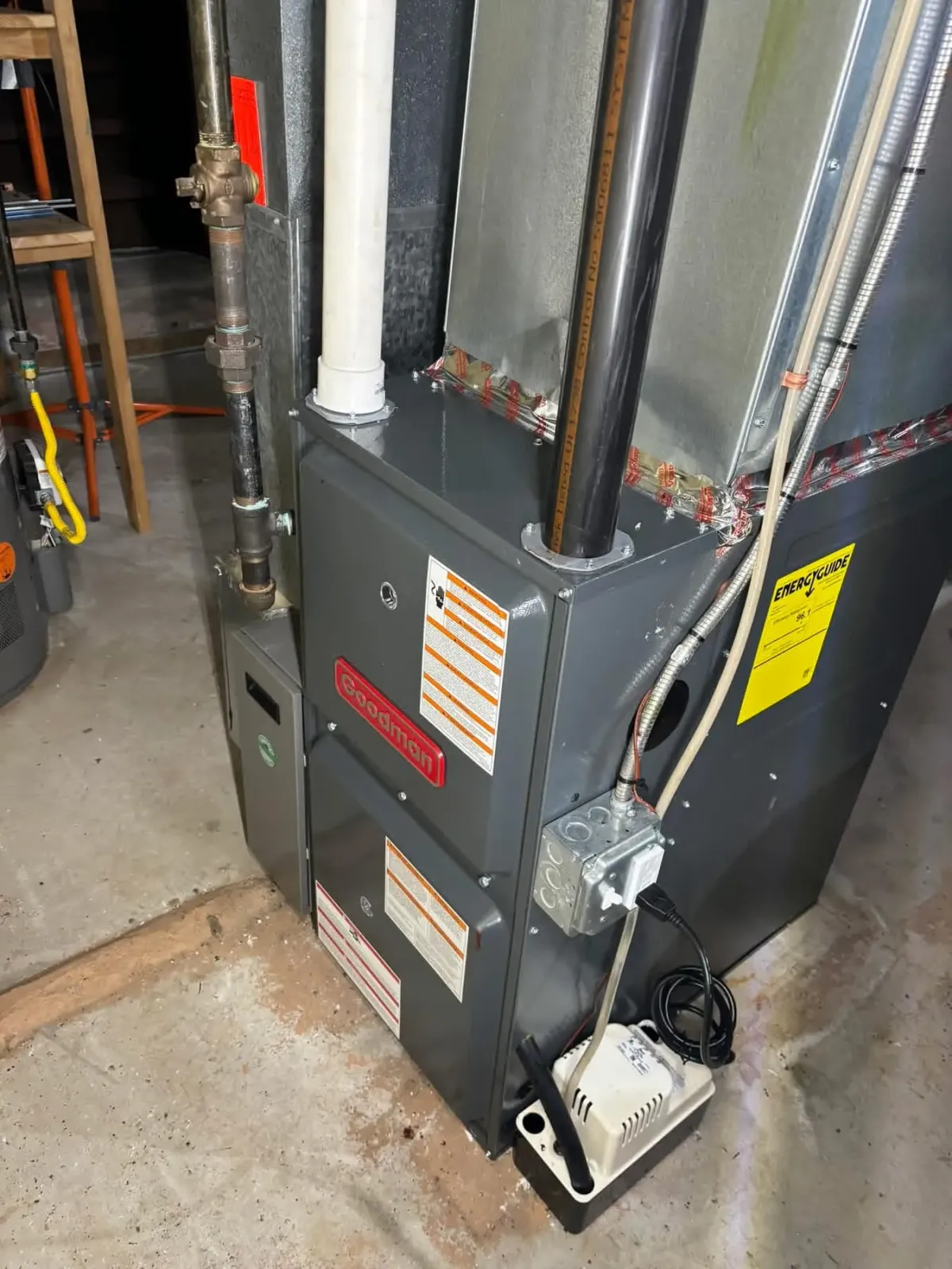 Goodman high-efficiency gas furnace with PVC venting in a basement utility area