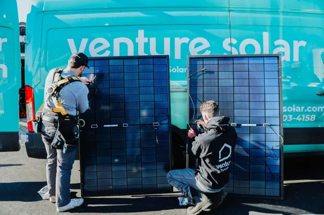 A group of men working on a solar installation, carefully setting up and maintaining efficient solar panels.