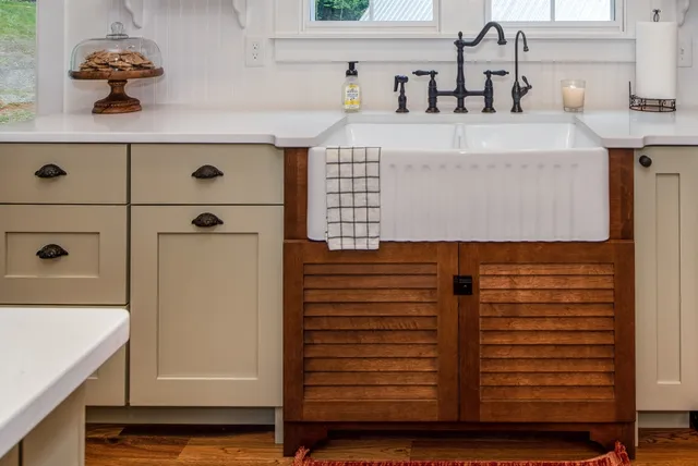 Sage cabinetry with fireclay apron sink and louvered sink base
