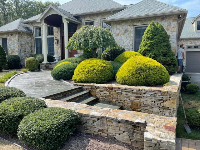 Stone veneer retaining wall, bluestone steps and landscaped front walkway at a Rhode Island home