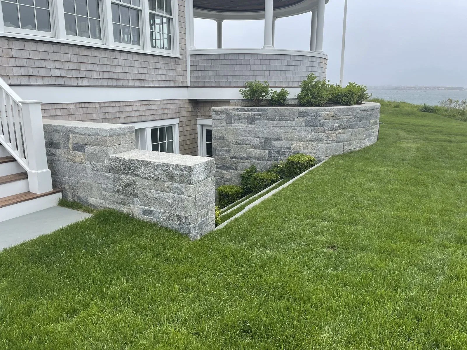 Hand-set fieldstone wall and stone steps on a Cape Cod property by Blue Claw Associates