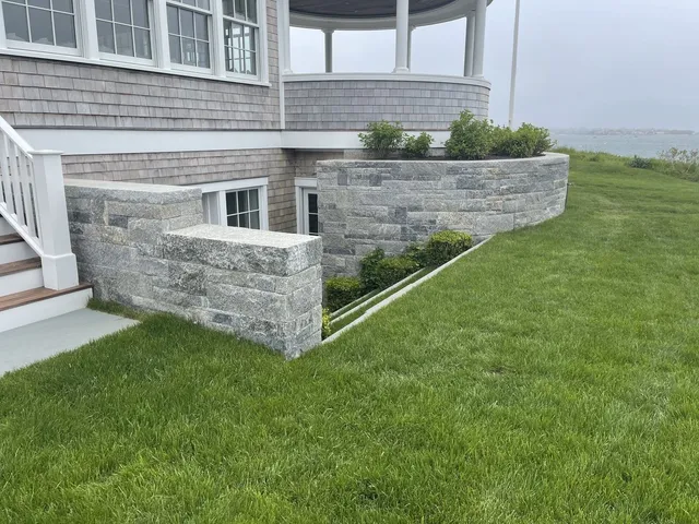 Hand-set fieldstone wall and stone steps on a Cape Cod property by Blue Claw Associates