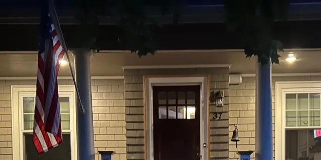 Exterior of home with porch lights and American flag on pole