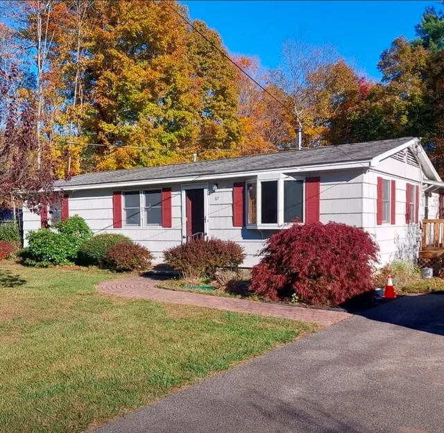 Exterior of a light gray ranch home with freshly painted red shutters