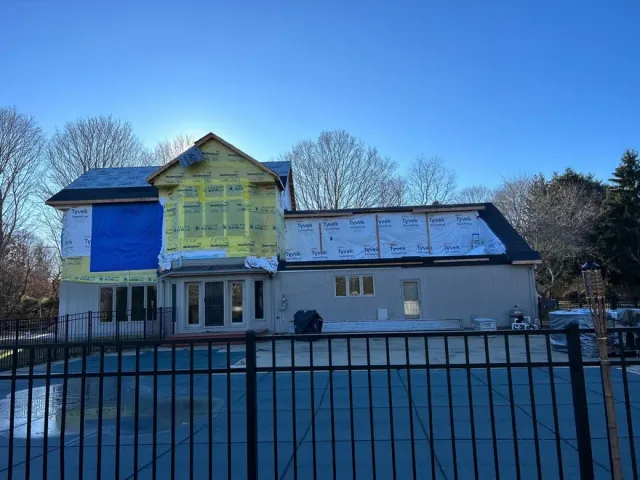 A house under construction with a fence in front of it
