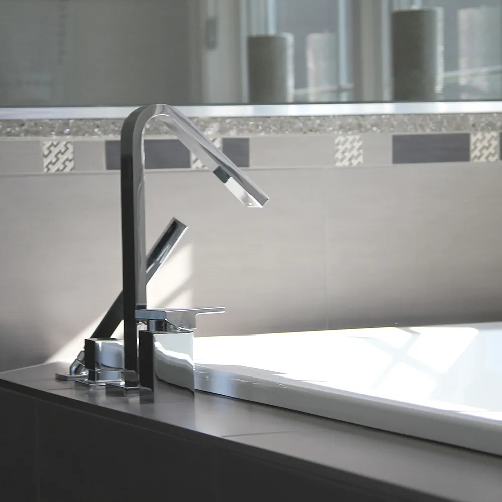 Modern bathroom with sleek chrome faucet and neutral-toned tiles.