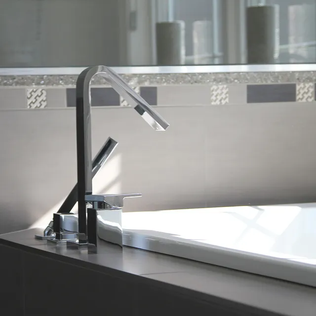Modern bathroom with sleek chrome faucet and neutral-toned tiles.